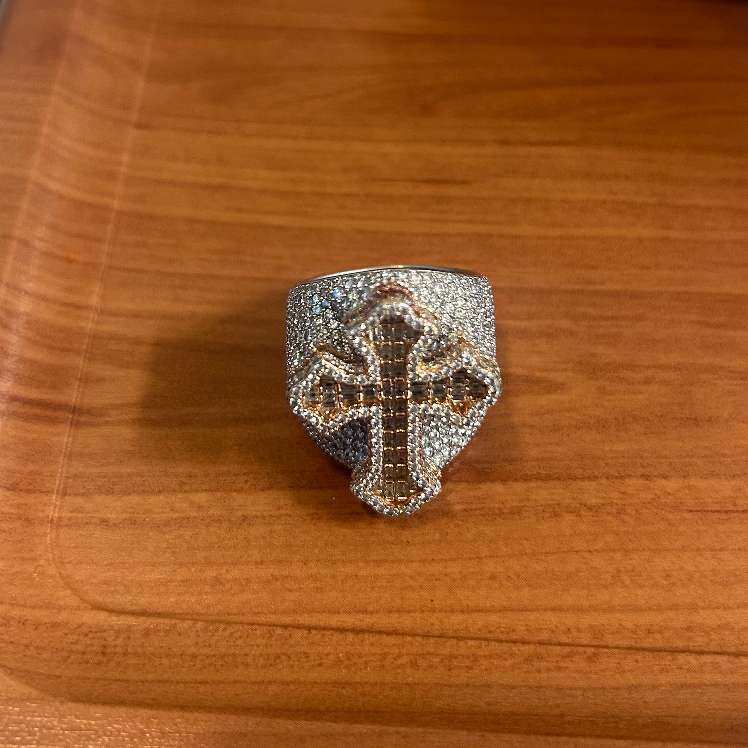 A ring made up of small stones with a gold cross emblem