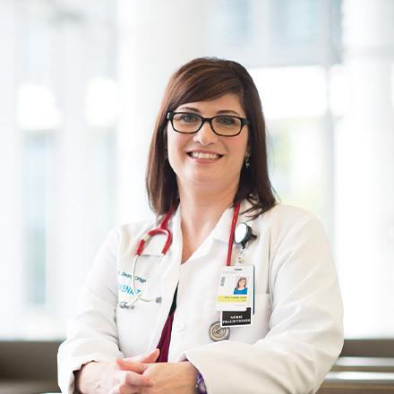 Female provider wear stethoscope around her neck smiling at the camera