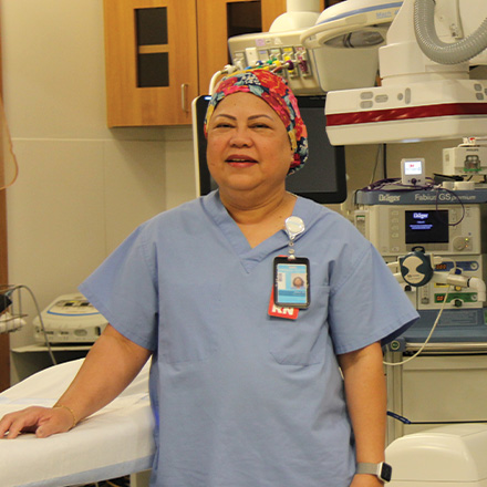 Nurse standing in front of minimally invasive procedure equipment