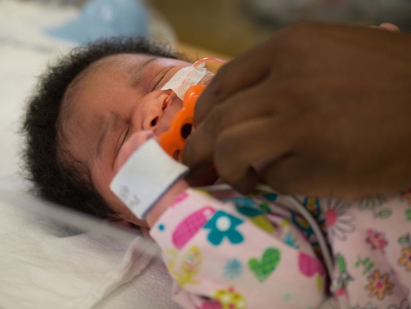 NICU baby receiving pacifier