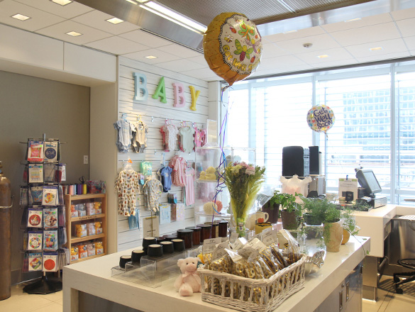 Interior of the Frank & Katrina Basile Gift Shop at Sidney & Lois Eskenazi Hospital with balloons, baby clothing, plants and other items