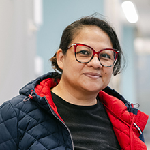 A woman in a coat looks at the camera