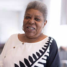 A smiling woman in a top with a bold pattern